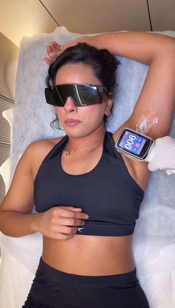 Woman receiving laser hair reduction treatment on the underarm at a professional skin and laser clinic.